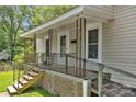 Inviting front porch featuring detailed railings, a small seating area, and convenient ramp access at 225 Institute St, Mooresville, NC 28115