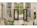 Bright foyer with decorative plants, a chair, and a view of the outdoors through the stylish front door at 225 Riverton Rd, Weddington, NC 28104