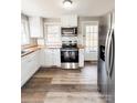 A bright kitchen with new stainless steel appliances, butcher block counters, and white cabinets at 32884 Old Salisbury Rd, Albemarle, NC 28001