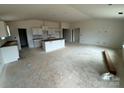 Spacious unfinished living room and kitchen with a vaulted ceiling and white cabinets at 338 Knotty Wood Dr # 69, Monroe, NC 28110