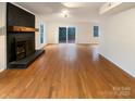 Spacious living room showcases hardwood floors and a classic brick fireplace, offering a cozy ambiance at 9105 Capsdale Ct, Huntersville, NC 28078