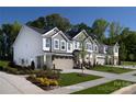 New townhome with a tandem two-car garage, beautiful landscaping, and sidewalks, adding to the curb appeal at 12233 Gambrell Dr, Charlotte, NC 28278