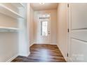 Bright entryway with hardwood flooring, white trim, coat hooks, and a glass-paneled front door at 12237 Gambrell Dr, Charlotte, NC 28278