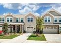 Inviting townhouse exterior featuring a well-manicured lawn, stone accents, and a two-car garage at 12237 Gambrell Dr, Charlotte, NC 28278