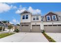 Charming townhome showcasing a three-car garage and tasteful exterior finishes including stone details at 12241 Gambrell Dr, Charlotte, NC 28278