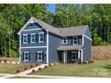 Inviting two-story home with a classic design, featuring navy siding and a lush green lawn at 1402 Richmond Dr # 1, Lowell, NC 28098