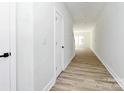 Bright hallway featuring light wood floors, white walls and trim, and a view into the main living space at 1508 Oak St, Charlotte, NC 28269