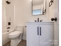 Modern bathroom with a decorative vanity, toilet and a shower and tub combo at 1522 Wickham Ln, Charlotte, NC 28208