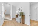 Bright entryway with wood floors, console table, decorative mirror and staircase at 3812 Odom Way, Charlotte, NC 28216