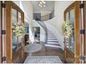 Elegant foyer with a curved staircase, chandelier, and hardwood floors, showcasing a bright, welcoming entrance at 400 Eden Hollow Ln, Weddington, NC 28104