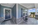 Inviting covered front porch featuring stylish decor, two chairs, and a view of the neighborhood at 5239 Admirals Lndg, Lancaster, SC 29720