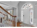 Bright foyer featuring hardwood floors, a staircase, and a decorative arched window above the front door at 9900 Silverling Dr, Waxhaw, NC 28173