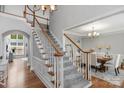 Elegant staircase leading to the second floor, showcasing hardwood floors and access to the dining room at 9900 Silverling Dr, Waxhaw, NC 28173