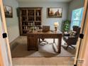 A styled home office including an executive desk, a bookshelf, a chair, and natural lighting at 1726 Still River Way, Fort Mill, SC 29708