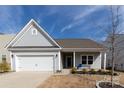 Charming single-Gathering home featuring a two-car garage, manicured lawn, and inviting front porch at 3156 Pinehills Way, Mount Holly, NC 28120