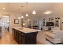Open-concept layout featuring kitchen island and seamlessly flowing into the living space at 3156 Pinehills Way, Mount Holly, NC 28120