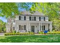 Charming two-story white brick home with black shutters, elegant columns, and large manicured lawn at 332 Hempstead Pl, Charlotte, NC 28207