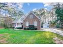 Well-maintained brick home featuring a detached garage and a lush, green lawn with mature trees surrounding the property at 340 Tradewinds Ln, York, SC 29745