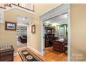 Open hallway leading to a sunroom and an office with wood floors and trim at 3419 Wylie Meadow Ln, Charlotte, NC 28269