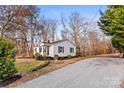 Exterior shot of a one-story home, featuring a gravel driveway and well-kept lawn at 426 Holland Memorial Church Rd, Bessemer City, NC 28016