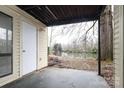 Covered back patio with a storage closet overlooking backyard trees and a pond at 4822 Spring Lake Dr # A, Charlotte, NC 28212