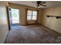 Bright living room featuring a ceiling fan, light-filled window, and access to the front porch at 509 California Cir, York, SC 29745