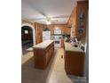 Spacious kitchen featuring wooden cabinets and island, with a refrigerator and gas range at 708 Mount Olive Church Rd, Newton, NC 28658