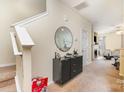 View of the foyer with stairs, cabinet and mirror plus a view of the fireplace in the living room at 8460 Summerglen Cir, Charlotte, NC 28227