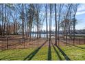 Picturesque backyard offers serene lake views framed by mature trees and a secure fence at 111 Kent Ct, Mooresville, NC 28117