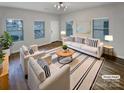 Staged living room with hardwood floors, natural light, and modern furniture at 120 Cadbury Ln, Fort Mill, SC 29715