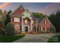Beautiful exterior featuring a brick facade, manicured landscaping, and a well-lit entrance, perfect for evening arrivals at 12011 Olden Ct, Charlotte, NC 28262