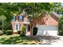 Traditional brick home featuring an attached two-car garage and a well-maintained lawn at 12541 Willingdon Rd, Huntersville, NC 28078