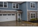 The home's exterior features a two-car garage, a stone facade, blue siding, and a well-kept lawn at 133 Batten Ridge Dr, Statesville, NC 28677