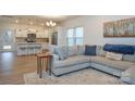 Open-concept living room featuring hardwood floors, a sectional sofa, and views of the kitchen at 133 Batten Ridge Dr, Statesville, NC 28677