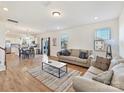 Bright, open-concept living area features hardwood floors, neutral paint, and seamlessly connects to the kitchen and dining area at 1444 Harleston St, Indian Trail, NC 28079