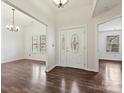 Bright foyer with an elegant front door, showcasing the home's open layout and hardwood flooring at 14621 Sapphire Ln, Pineville, NC 28134
