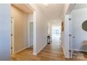 Bright hallway with hardwood floors leads to various rooms, showcasing the home's layout and natural light at 2513 Crimson Way, Monroe, NC 28112