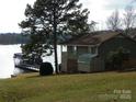 Picturesque waterfront property featuring a charming house, shed, and dock, ideal for lakeside enjoyment at 254 N Shoreline N Dr # 38, New London, NC 28127
