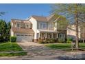 Attractive two-story home with stone facade, front porch and attached two car garage on a tree-lined street at 3216 Bridgewick Rd, Waxhaw, NC 28173