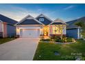 Charming single-Gathering home showcasing a well-manicured lawn, inviting front porch, and attached two-car garage at 4023 Gozzi Dr, Iron Station, NC 28080