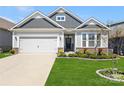 Well-maintained home displaying a manicured lawn, lush landscaping, and an attached garage, creating curb appeal at 4023 Gozzi Dr, Iron Station, NC 28080
