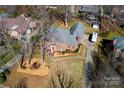 Aerial view of the home showing its brick exterior, mature trees, driveway, and ample parking space at 5304 Woodridge Dr, Monroe, NC 28110