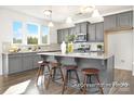 Modern kitchen featuring gray cabinets, stainless steel appliances, granite countertops, and a breakfast bar with seating at 731 Gondola Ct # 117, Salisbury, NC 28144
