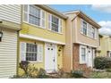 A charming two-story townhouse with bright yellow siding and white shutters at 7344 Pebblestone Dr # E, Charlotte, NC 28212