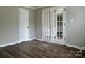 Room featuring hardwood floors, grey walls, standard door, and glass panel doors into another room at 8812 Glenover Cir, Charlotte, NC 28269