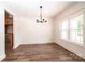 Dining room features wood flooring, modern chandelier, and a bright window with natural light at 0 6Th Nw St, Hickory, NC 28601