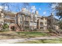 Beautiful condo building with manicured lawn and mature trees on a sunny day at 1101 E Morehead St, Charlotte, NC 28204