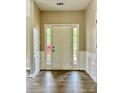 Bright foyer with wood-look flooring, white trim, and a view of outdoor greenery through sidelight windows at 11339 Fox Hill Dr, Charlotte, NC 28269