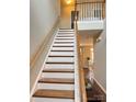 Staircase with wood treads and white risers leads to the upper level of the home at 14809 Castletown House Dr, Charlotte, NC 28273