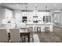 Modern kitchen with stainless steel appliances, white cabinets, an island with seating, and an adjacent dining area at 1809 Ab Moore Jr Dr # 3238, Indian Trail, NC 28079